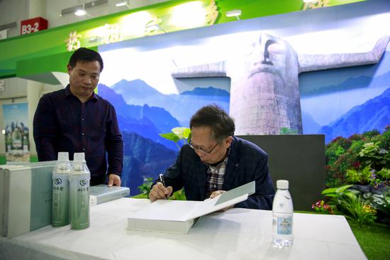 詹亚华健博会现场签售《神农架中药资源图志》(郭裕铭摄)